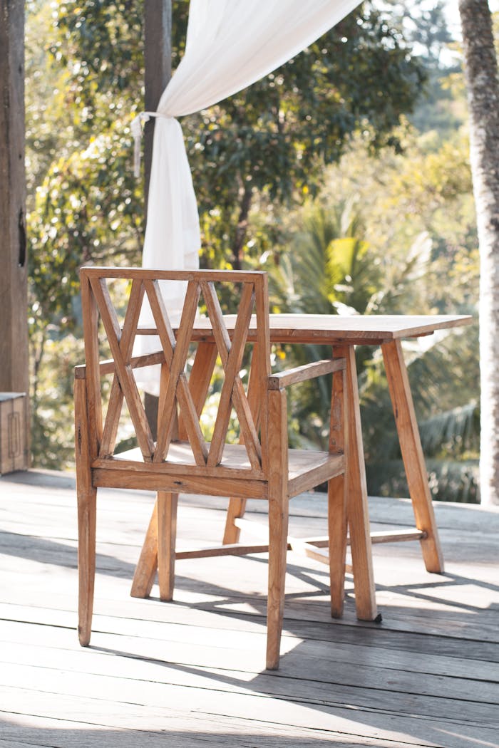 Wooden chair and table on a bright patio, perfect for relaxation.